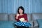 Young asian woman watching television suspense movie or news looking happy and funny and eating popcorn late night at home living