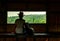 Young Asian woman wear the hat sit on wooden bench and watching beautiful view of tropical forest at wildlife observation tower