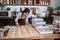 Young Asian woman wearing an apron while arranging donuts with clip food on the table