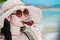 Young Asian woman wearing Hawaiian with hat and sunglasses is happy when they go to the beach