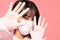 Young asian woman wearing protection mask or surgical mask for protected virus and air pollution making hand stop