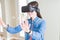Young asian woman wearing virtual reality glasses smiling and concentrated playing video games