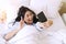 Young Asian women black long hair holding smartphone in her hands while lying up on the white bed selfie her face to social