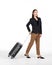 Young asian women in black suit smiles as she walks dragging a black suitcase. Portrait on white background with studio light