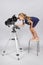 The young astronomer standing on a chair and funny looking in a telescope eyepiece
