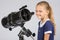 Young astronomer at the telescope is smiling and looking to the frame