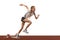 Young athlete, beginner female track runner bursting off starting block isolated over white background. Sport, workout