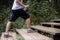 A young athlete climbs a wooden staircase in running shoes in the park