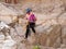 Young athlete descending with equipment for rappel in mountains of Judean Desert, near Rahaf stream, near Jerusalem, Israel