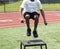 Young athlete jumping onto plyo box during summer sports camp