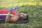 Young athlete lies on his back on the grass during a pause on a