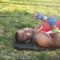 Young athlete lies on his back on the grass during a pause on a