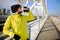 Young athlete man drinking water - rehydrating during exercise outdoors