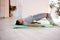 Young athlete performs a glute bridge on a fitness mat using an elastic band