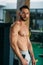 Young athlete posing with a torso for photography on a brick wall background. Bodybuilder, athlete with pumped muscles.