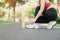 Young athlete woman tying running shoes with Energy Drink water, female runner ready for jogging outside, asian Fitness walking