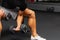 Young athlete Working out biceps at the gym.Closeup muscular young man lifting weights in gym on a dark background