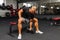 Young athlete Working out biceps at the gym.Closeup muscular young man lifting weights in gym on a dark background