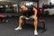 Young athlete Working out biceps at the gym.Closeup muscular young man lifting weights in gym on a dark background