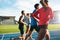 Young athletes running on race track in stadium