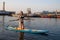 Young athletic female paddling on a SUP stand up paddle board in blue water sea. Summer, vacation, sup paddleboarding or