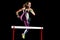 Young athletic girl jumping over obstacle isolated
