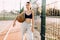 Young athletic girl, outdoors, posing with a basketball. Sport, fashion