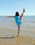 Young athletic girl Perform rhythmic gymnastics exercises on the sea water