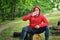 Young athletic jogger in a red jacket with a hood and black