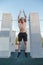 Young athletic man doing burpee on parkour area. Training alone outdoors.