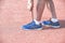 Young athletic man lacing his sneakers ready for sportive training and running on a red track. Cardio and health activity concept.