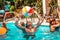 A young athletic man plays in the pool with an inflatable ball. Women swimming in the pool, and sun loungers on the beach, in the