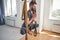 Young athletic man practicing aerial yoga indoors