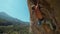 young athletic man rock climber with long hair climbing on the overhanging cliff. male climber climbing very hard route