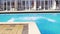 Young athletic man in swim shorts falling to the swimming pool. Slowmotion shot.