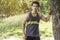 Young athletic man taking a break under tree during a challenging jogging outdoor .