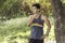 Young athletic man taking a break under tree during a challenging jogging outdoor .