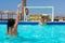 Young athletic pair playing water polo at the hotel