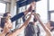 Young athletic people in sportswear giving high five in gym