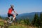 Young athletic professional tourist stopped on top of hill to enjoy beautiful view of mountains