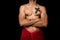 Young athletic shirtless man posing on black background