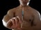 Young athletic sportsman holding syringe in sport doping and cheat concept