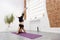 Young athletic woman doing a handstand at home. Pilates, yoga, fitness and training concept