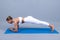 Young athletic woman doing plank. Yoga woman takes yoga courses. Peaceful sporty athletic girl in sportswear exercising