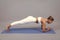 Young athletic woman doing plank. Yoga woman takes yoga courses. Peaceful sporty athletic girl in sportswear exercising