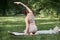 Young athletic woman doing yoga or outdoor sports in the park, rear view.