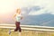 Young athletic woman jogging on road in mountains