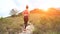 Young athletic woman running on mountain trail. Sunset Workout in Nature. Fit girl in pink top run.