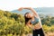 Young athletic woman warming up during a workout in the Park. The concept of yoga, sports and meditation. In the background view