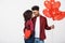 Young attactive African American couple holding heart balloon and paper.